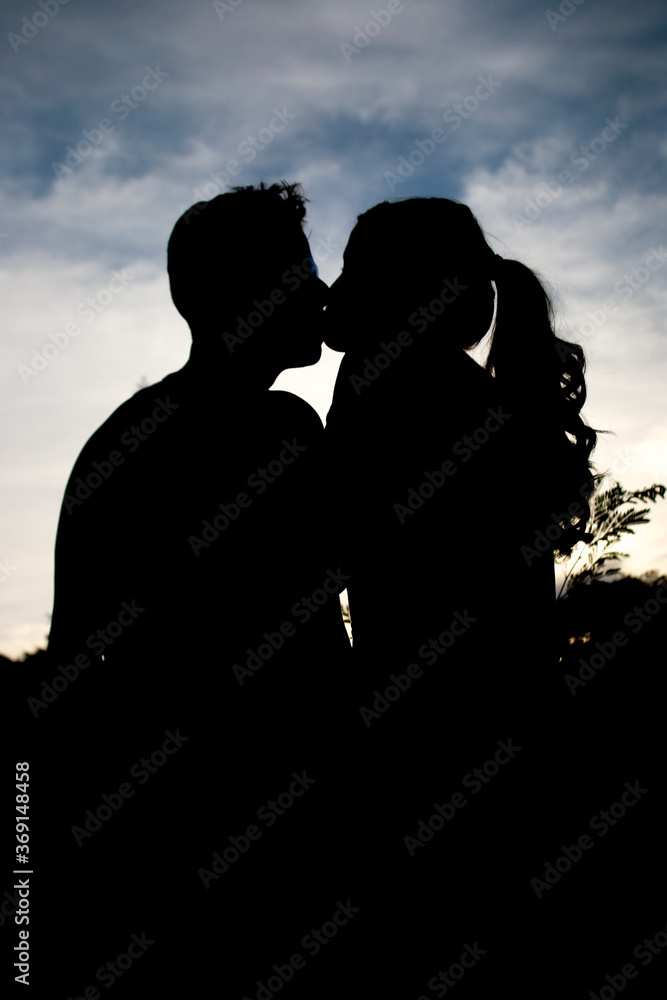 Silhouettes of people, with the sun in the background.