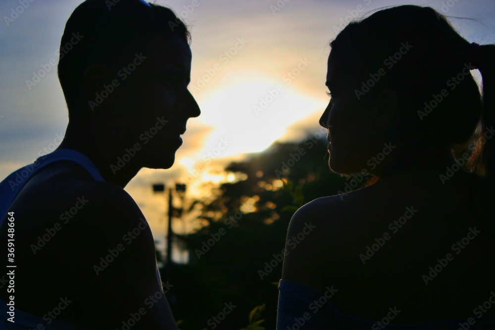 Silhouettes of people, with the sun in the background.
