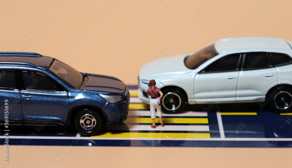 Miniature people and miniature cars. A concept about warning of the risk of using a Smartphone when crossing a crosswalk.
