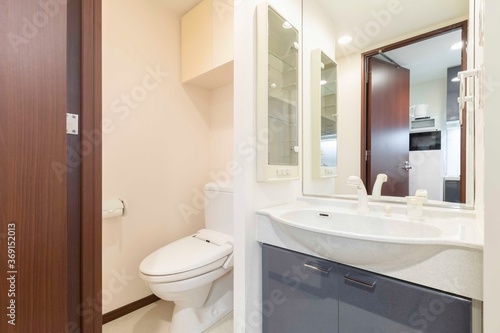 Wash basin and Automatic flush toilet inside a small modern shower room in the apartment