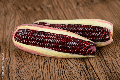 fresh purple corns on wooden background photo