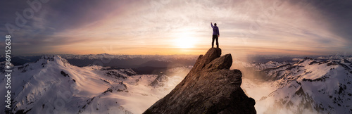 Magical Fantasy Adventure Composite of Man Hiking on top of a rocky mountain peak. Background Landscape from British Columbia  Canada. Sunset or Sunrise Colorful Sky