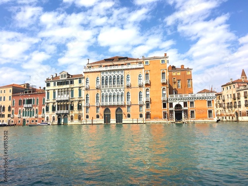 Beautiful view of a venician palace  on a venetian canal with red ocre  orange and yellow building facade  Venice  Italy.