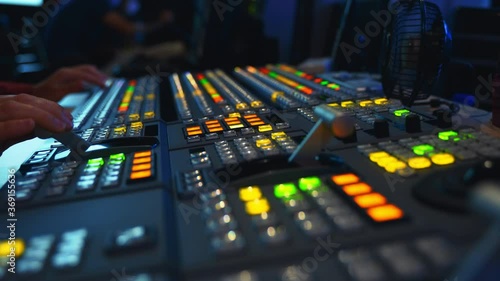 Broadcast Tv Studio Production - Vision Switcher Studio Director broadcast video mixer operation - Close-up of hand. Hands of a cinematographer who worked on the vision mixer, switch the TV panel. photo