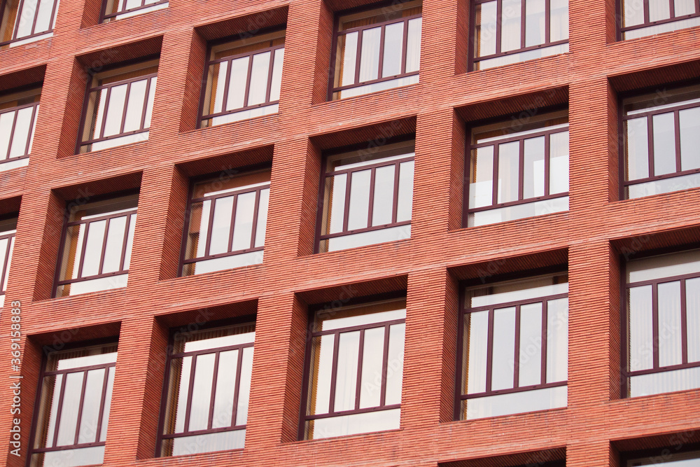 Urban texture and pattern. Architecture. Closeup view of the building facade. The apartment windows and the red brick wall. Urban texture and pattern. Architecture. Closeup view of the building facade. The apartment windows and the red brick wall.