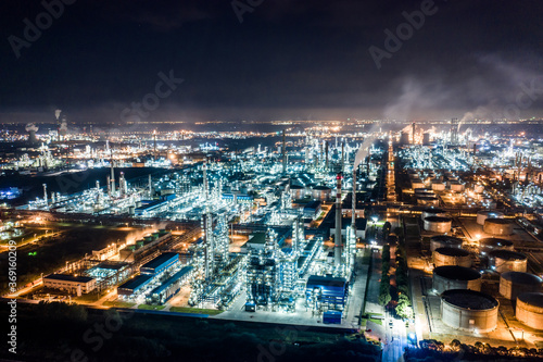 Aerial view oil and gas tank with oil refinery background at night photo