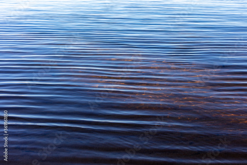 Small waves on surface of clear lake water