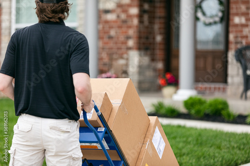 Shipment: Man Pushes Dolly With Boxes To Home