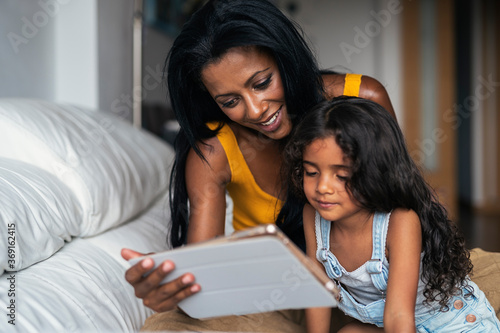 Mother and daughter using device at home