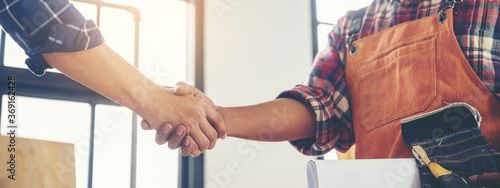 Two carpenters holding hands, The concept of working together until success
