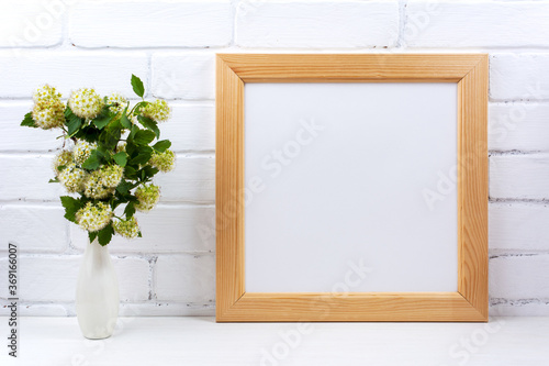  Square wooden picture frame mockup with white spirea © TasiPas