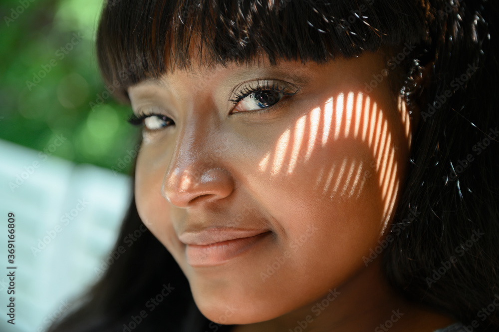 Woman with pattern made from shadow on her face