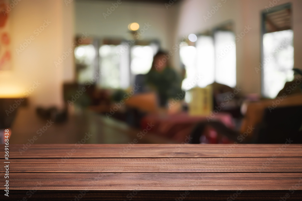 Empty wooden desk space and blurry background of coffee shop or Restaurant for product display montage.