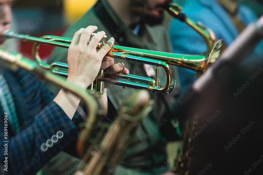 Obraz premium Concert view of a male trumpeter, professional trumpet player with vocalist and musical during jazz band performing