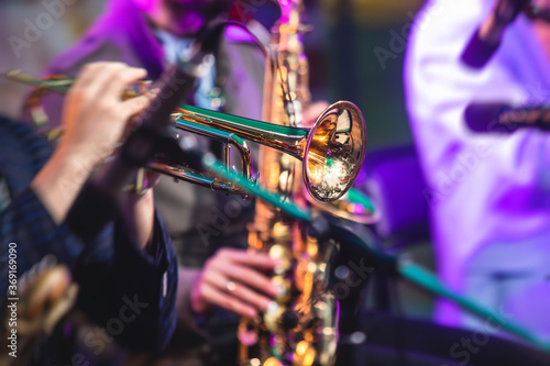 Concert view of a male trumpeter, professional trumpet player with vocalist and musical during jazz band performing photo