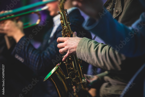 Photography Concert view of a saxophonist, saxophone player with vocalist and musical during