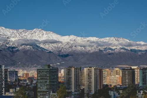 Lonely clouds in the sky over Santiago skyline and the snowed Los Andes mountains, Chile