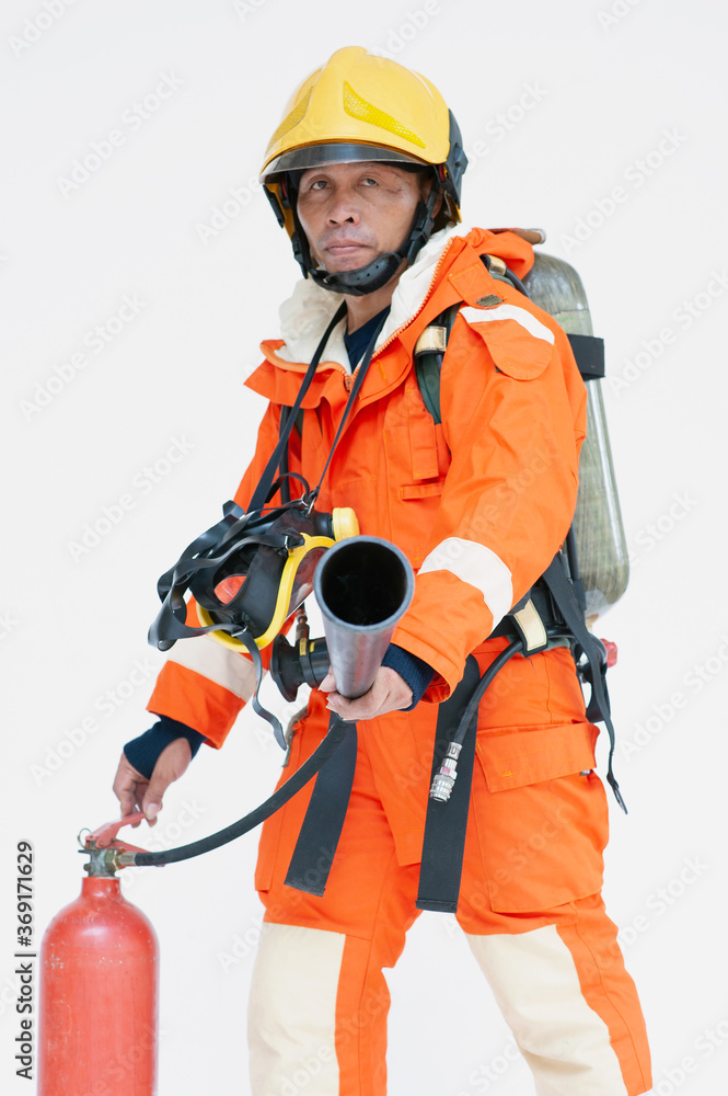 A portrait of Asian male firefighter in red protective uniform, mask and helmet with fire extinguisher standing on white background. A portrait of Asian male firefighter in red protective uniform, mask and helmet with fire extinguisher standing on white background.
