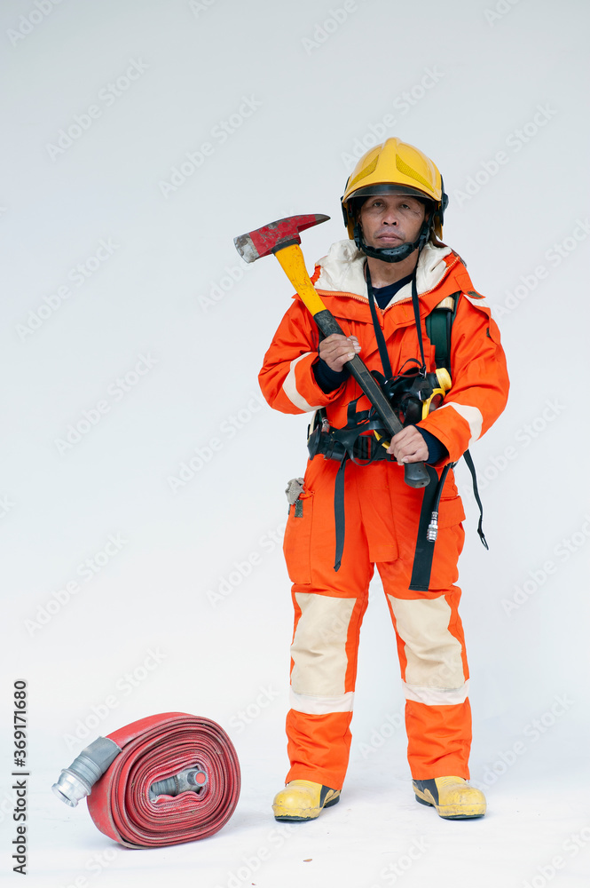 A portrait of Asian male fireman in red protective clothing, mask and helmet with an ax standing on a white background. A portrait of Asian male fireman in red protective clothing, mask and helmet with an ax standing on a white background.