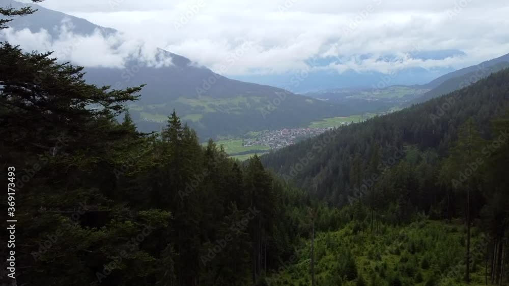 Drone flight over green and rainy forrest in TIrol, Austria. View upon a small village in the background. Aerial footage. Drone flight over green and rainy forrest in TIrol, Austria. View upon a small village in the background. Aerial footage.