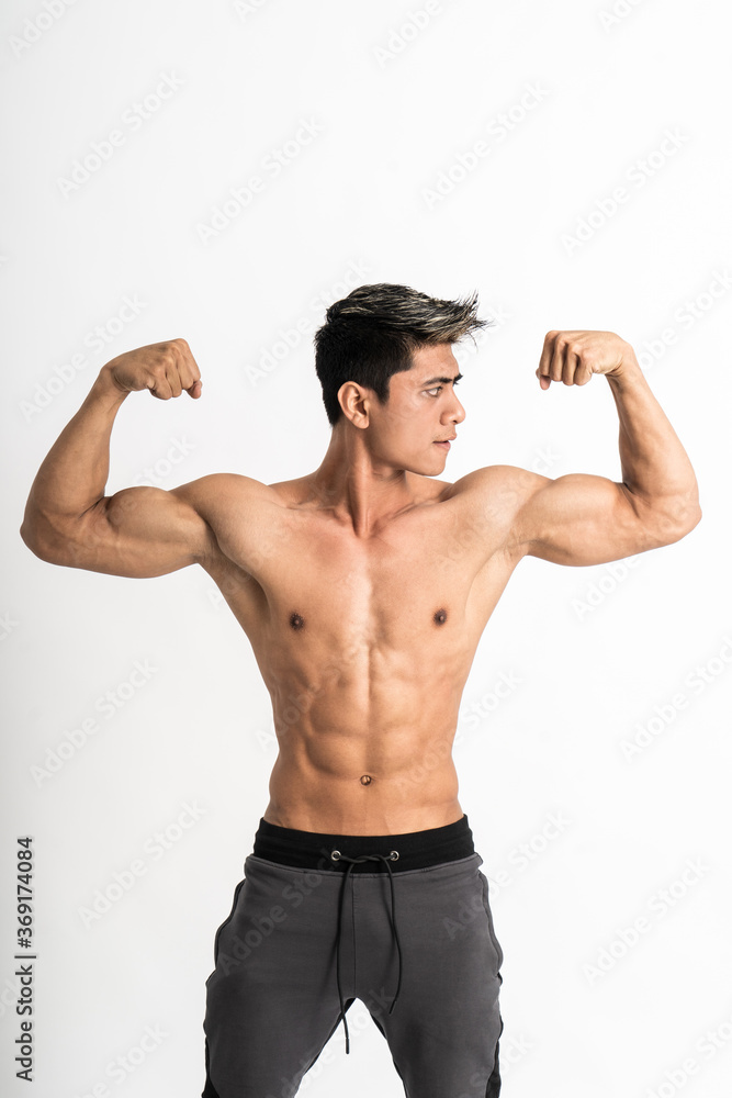 young man showing muscular biceps stand facing forward on isolated background young man showing muscular biceps stand facing forward on isolated background