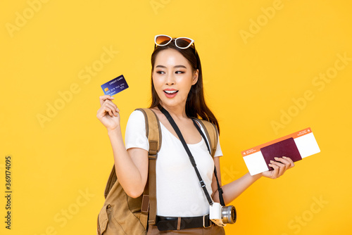 Smiling Asian woman tourist showing credit card for payment on vacation traveling