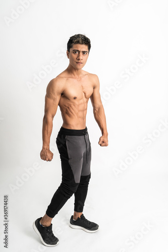 full body image of asian young man showing a muscular side belly stand facing side on isolated background