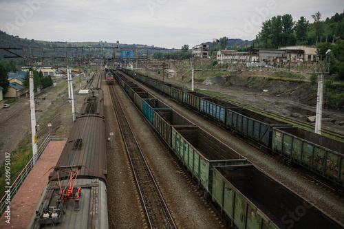 Top view of a railway marshalling yard with railroad cars. Coal industry. Commodity train with coal. Coal wagons, coal transportation in freight wagons. Formation of a coal train in a freight depot. 