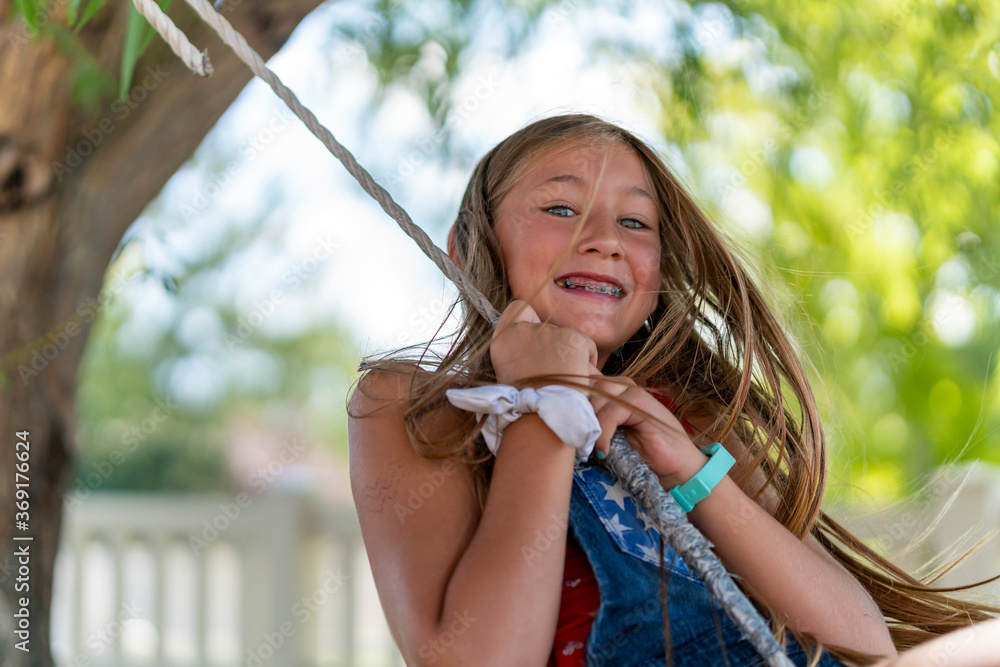 preteen Candid portrait of a preteen girl on a rope swing Stock 写真 | Adobe Stock