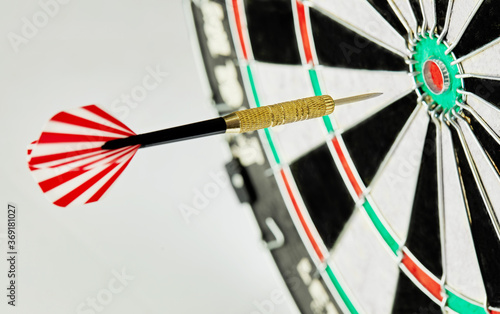 Darts on a white background. 1 dart flies directly to the center of the target. Business center goal concept