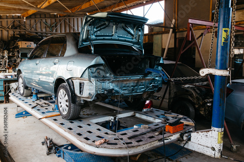 Wallpaper Mural A blue car is lifted on a lift for repair in a car service center Torontodigital.ca