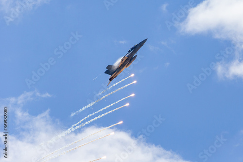 Fighter jet aircraft firing countermeasures flares to avoid missiles.