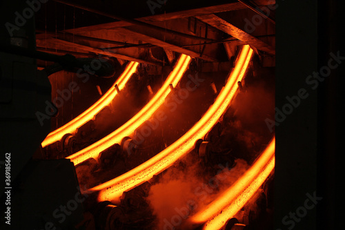 Red hot steel metal billets after molten steel casting.  Continuous casting machine. Background of the blacksmith and metallurgical industry.