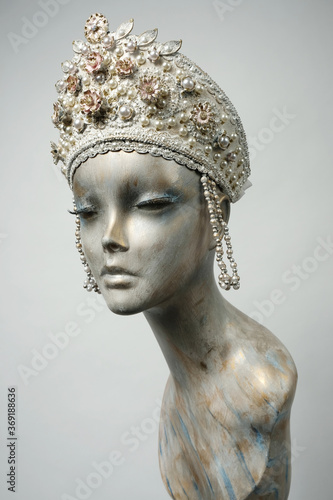 Head of mannequin in creative white headwear with flowers and pearls
