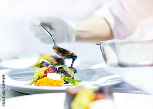 Quadro su tela Chef cooking, Chef preparing food in the kitchen, Chef decorating dish, closeup