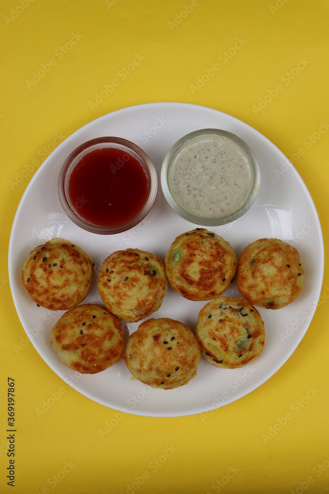 Appum or Appe, Appam or Mixed dal or Rava Appe served with green and red chutney. A Ball shape popular south Indian breakfast dish, Selective focus