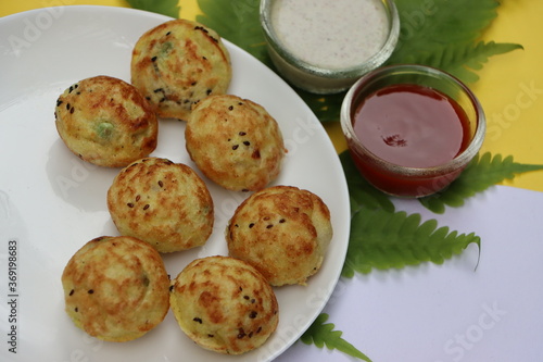 Appum or Appe, Appam or Mixed dal or Rava Appe served with green and red chutney. A Ball shape popular south Indian breakfast dish, Selective focus photo