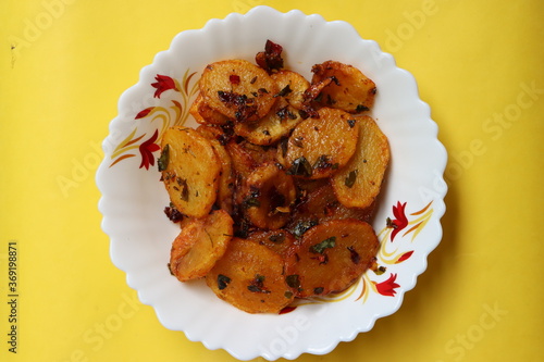 Aloo Katli or Potato Katli is an excellent and tasty asian dish, slices of fried potatoes, sauces and herbs, snack or starter  photo