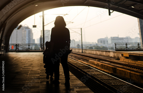 silhouette passenger walking on walkway at eletrict train station