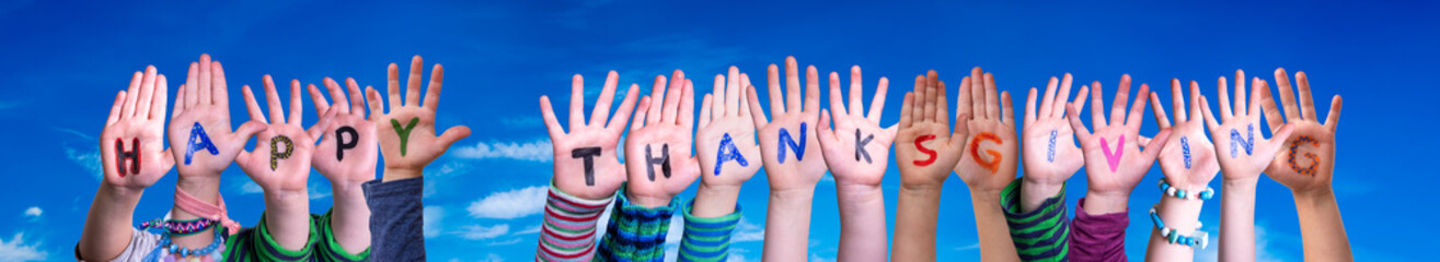 Children Hands Building Colorful English Word Happy Thanksgiving. Blue Sky As Background