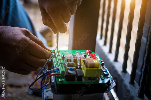 A Technician assembling motor system and testing motor automatic gate by screwdriver home security system.