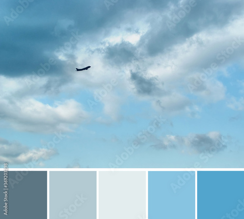 фотографія Beautiful dramatic gray and white clouds on light blue sky and a silhouette of airplane