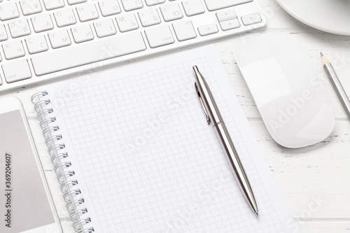 Office workplace with computer, notepad and smartphone