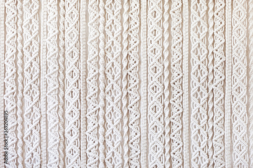 Close-up of hand made macrame texture pattern. ECO friendly modern knitting DIY natural decoration concept  in the interior. Flat lay. Handmade macrame 100% cotton. Female hobby.