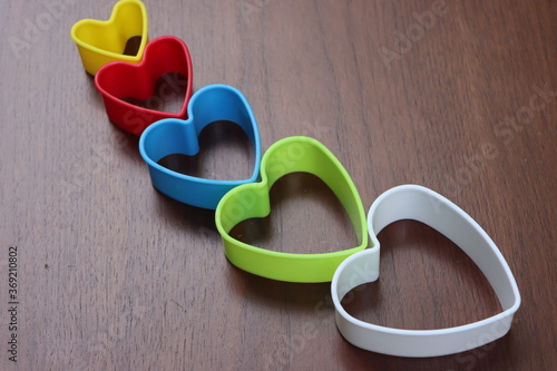 Fotografi Heart shaped cookie cutters on wooden table, love concept
