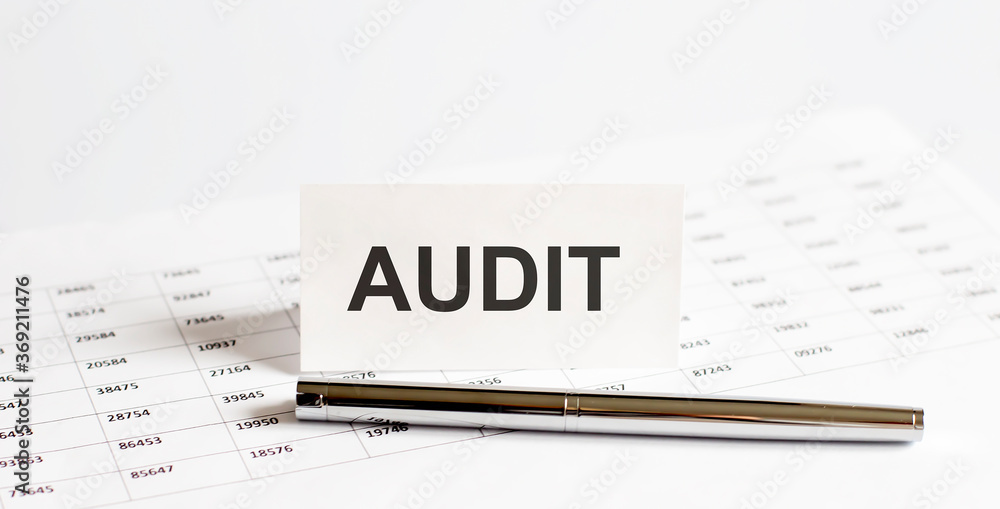 Text AUDIT on stickers,pen on the background of documents. Financial bookkeeping, Accounting Concept. Top view. Text AUDIT on stickers,pen on the background of documents. Financial bookkeeping, Accounting Concept. Top view.