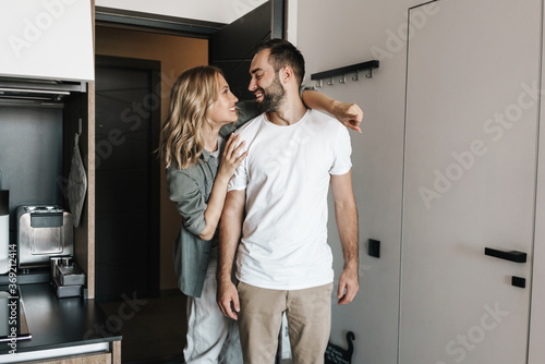 Loving couple standing together indoors at home