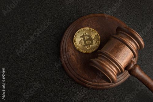 Judge gavel and bitcoin. Cryptocurrency legislation. Bitcoin ban. Violation of law.