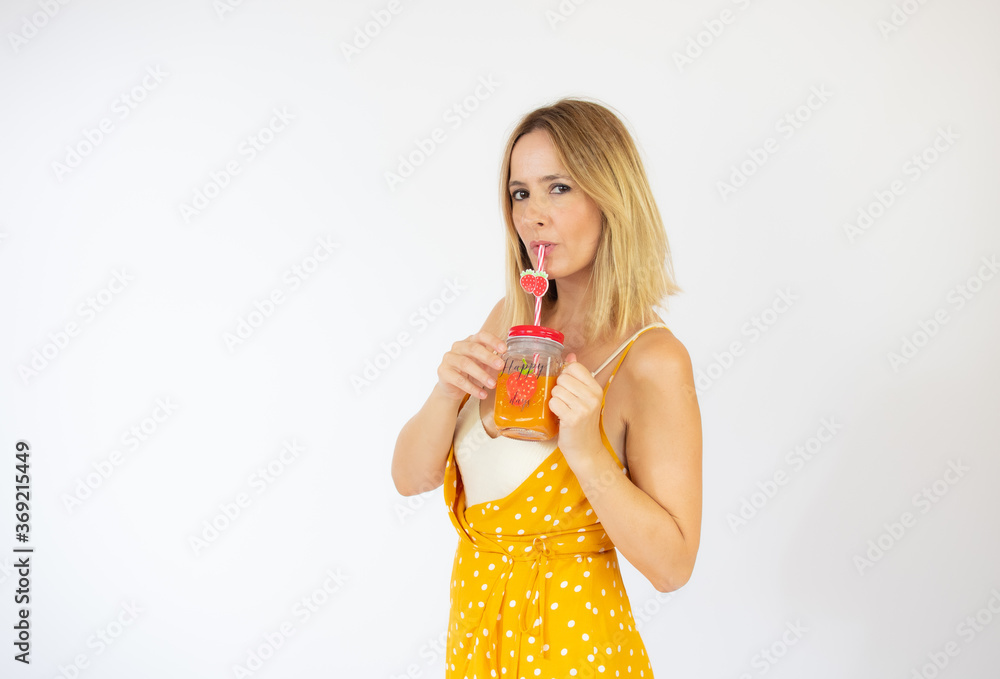 Beautiful woman in yellow dress with a juice