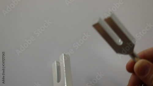 metal tuning forks hitting each other close-up